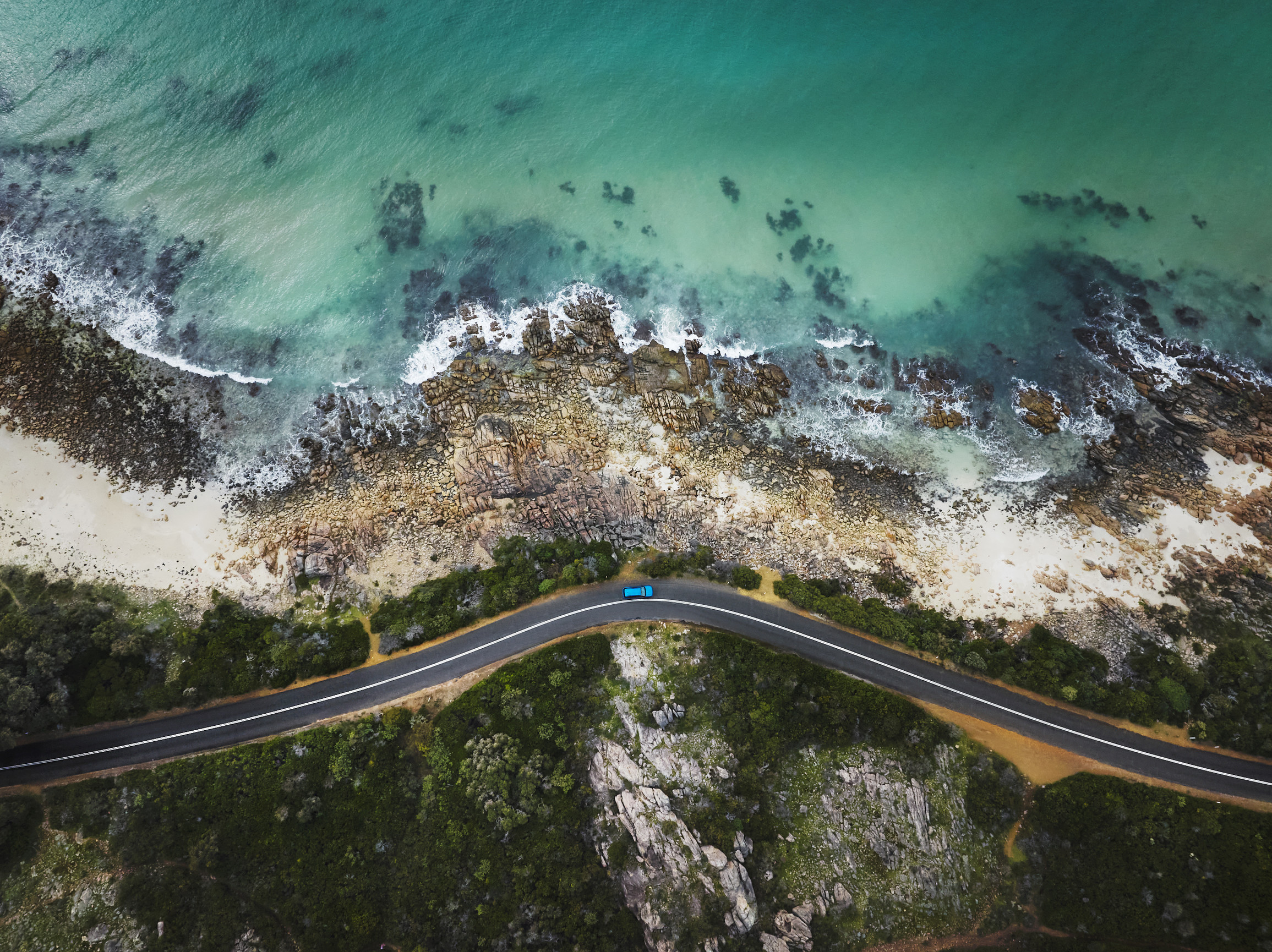 A lone vehicle driving along the oceanside road near Point Pique, Geographe Bay