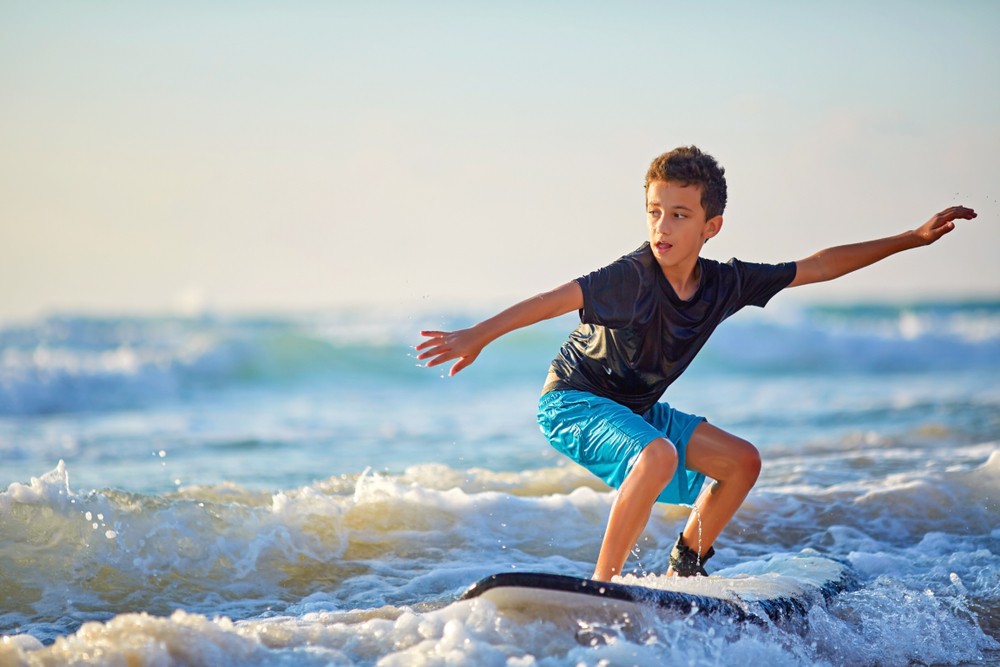 A kid learning to surf on very gentle waves